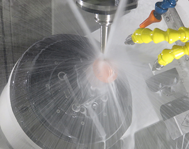 A close up of a machining application with coolant spraying